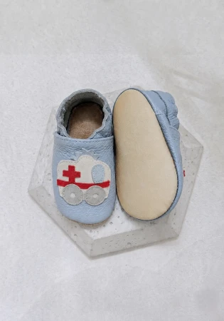 Śliczne, lekkie i wygodne kapcie barefoot funky-monkey z niebieskiej włoskiej skóry z kauczukową antypoślizgową podeszwą i motywem karetki dla każdego chlopca